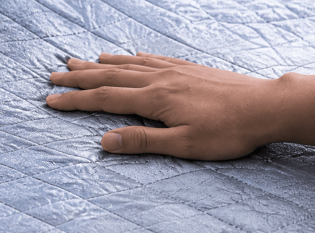 A hand resting on the silver quilted fabric