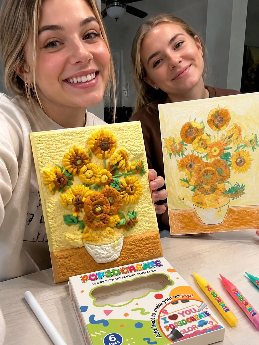 Two customers displaying handmade textured sunflower paintings.